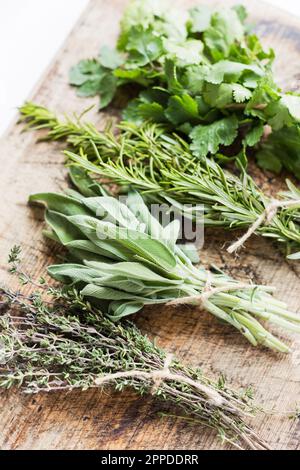 Bunch of fresh herbs on wooden table at home Stock Photo