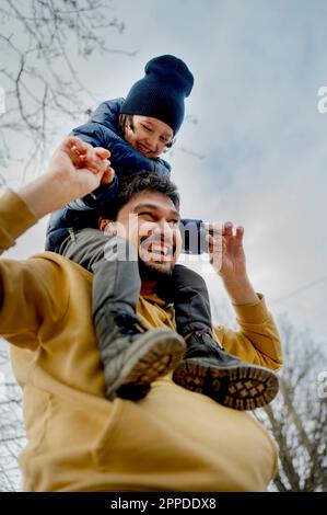 Father playing with son sitting on shoulder Stock Photo