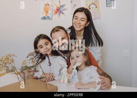 Happy parents arm around with daughters at home Stock Photo