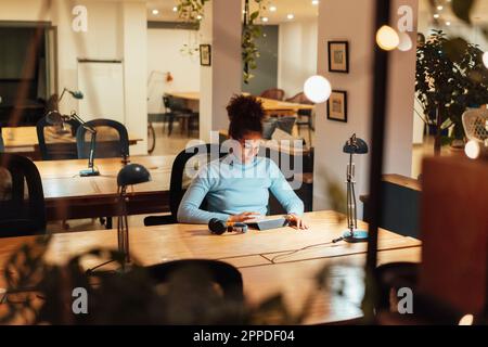 Businesswoman working on laptop at night in office Stock Photo