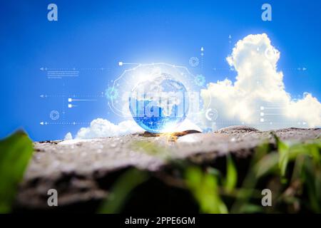 Globe on ground and grass with blue sky and cloud background. Ecology concept Stock Photo