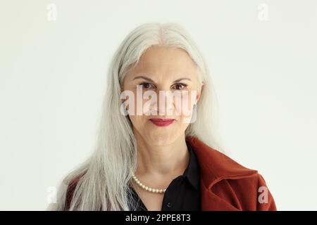 Attractive senior woman with long grey hair poses in studio Stock Photo