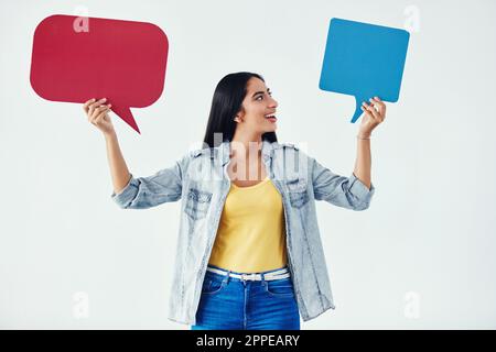 And his reply was...Studio shot of an attractive young woman holding speech bubbles. Stock Photo