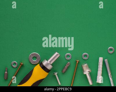 Green background with hand tools, metal fasteners and fittings. Industrial design with copy space. Tools, worker concept. Stock Photo