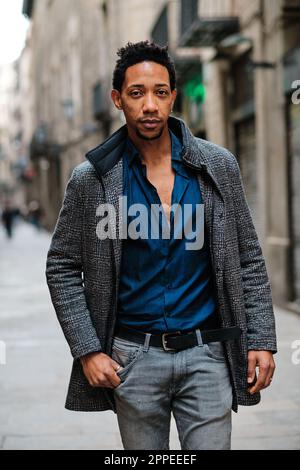 Stylish black man looking at camera while posing outdoors on the street. Stock Photo