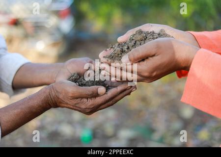 Indian farmer holding soil in hands, happy farming, Dropping soil in other hand Stock Photo