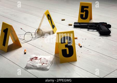 Evidences and crime scene marker on white wooden table Stock Photo