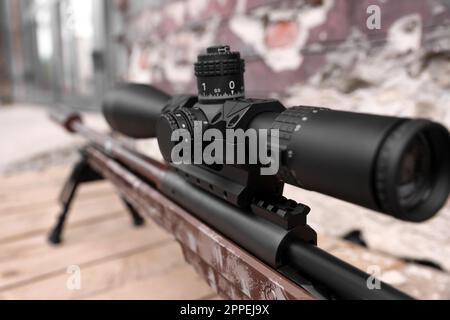 Closeup view of modern powerful sniper rifle with telescopic sight outdoors Stock Photo