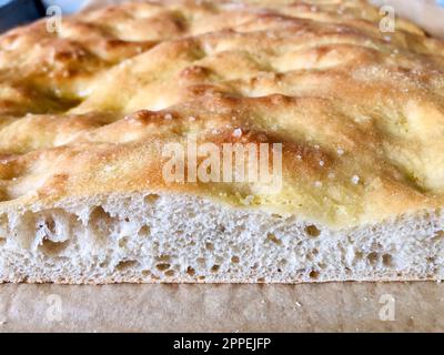 Italian focaccia. Freshly baked and sliced Italian white pizza in a pan. Pizza bread. Roman pizza. Stock Photo