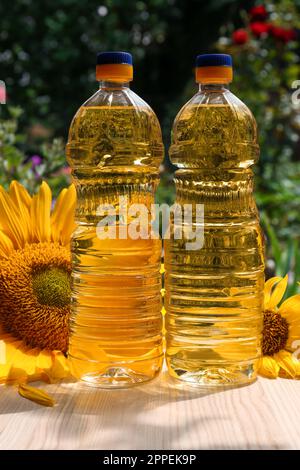 Bottles of sunflower oil on wooden table outdoors Stock Photo