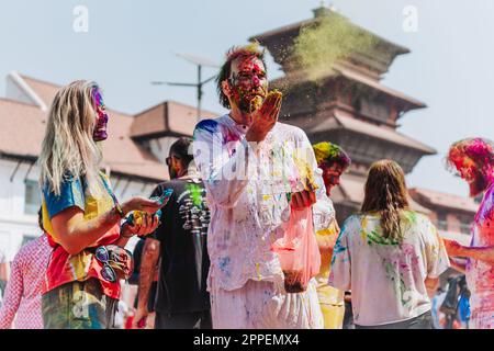 KATHMANDU, NEPAL - MARCH 6, 2023: Tourists enjoying Happy Holi festival at Basantapur Durbar Square in Kathmandu. Holi is a spring festival celebrated Stock Photo