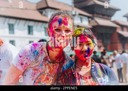 KATHMANDU, NEPAL - MARCH 6, 2023: Tourists enjoying Happy Holi festival at Basantapur Durbar Square in Kathmandu. Holi is a spring festival celebrated Stock Photo