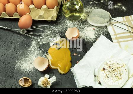 A broken egg on the table, a mess at the cook's workplace. Chicken egg dropped on the table. Place for text Stock Photo