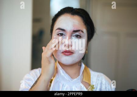 Woman painting face for Halloween Stock Photo