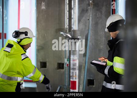 Male and female engineer working at construction site Stock Photo