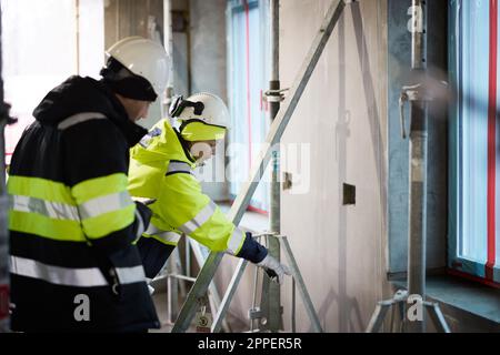 Male and female engineer working at construction site Stock Photo