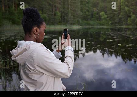 Young woman taking photo with cell phone Stock Photo