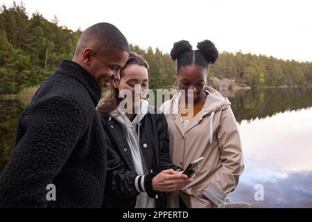 Young friends looking at cell phone Stock Photo