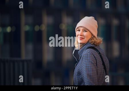 Smiling young woman wearing headphones outdoors Stock Photo