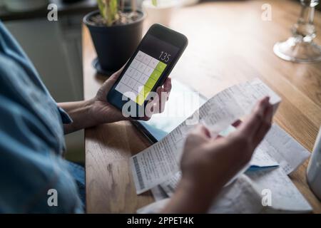Woman organizing household budget with calculator Stock Photo