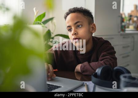 Boy at home using laptop Stock Photo