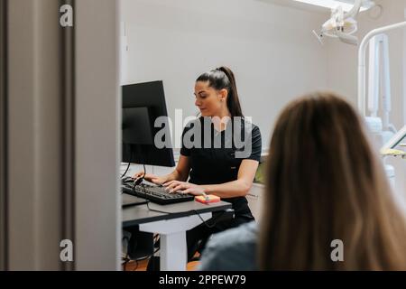 Female dentist using computer in office Stock Photo