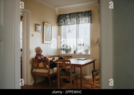 Senior man using smart phone at home Stock Photo