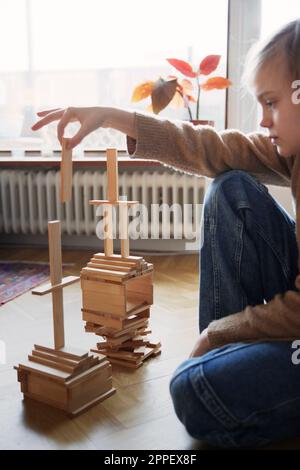 Girl arranging tower of wooden blocks Stock Photo