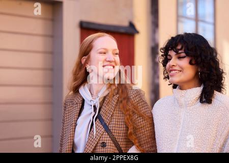 Smiling young women walking outdoors Stock Photo