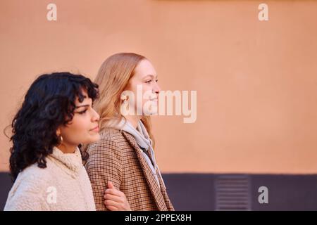 Smiling young women walking outdoors Stock Photo