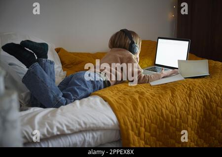 Girl using laptop in her bedroom Stock Photo