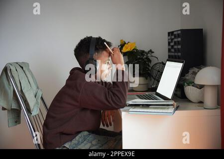 Boy doing homework with laptop Stock Photo