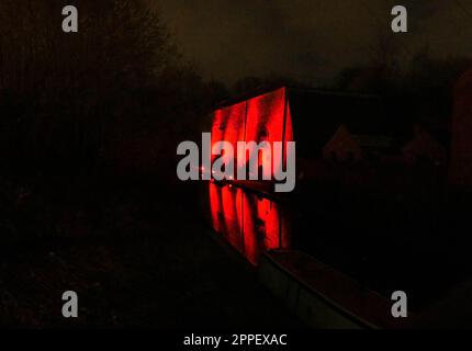 Red lights illuminating a brick wall and reflected back onto the canal at the Black Country Living Museum Dudley. March 2023 Stock Photo