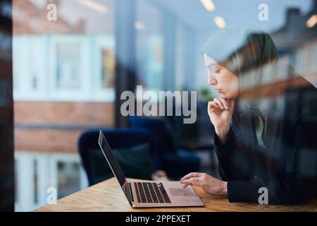 Woman in cafe using laptop Stock Photo