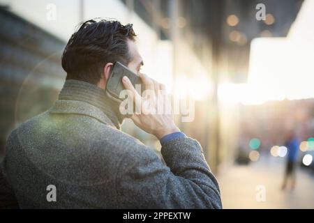 Businessman talking on phone outdoors Stock Photo