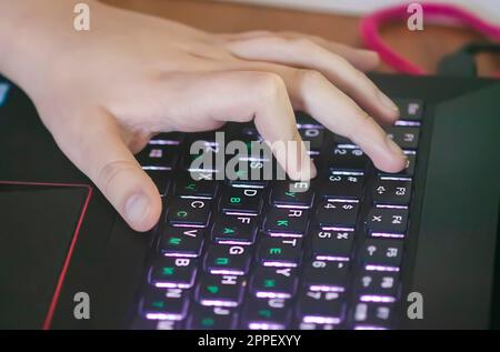 Hands of child using laptop Stock Photo