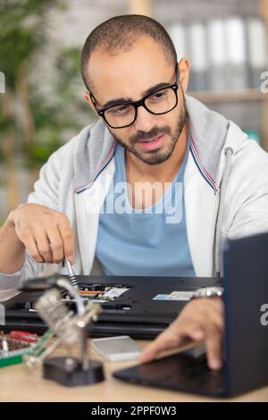young energetic male tech or engineer repairs electronic equipmen Stock Photo