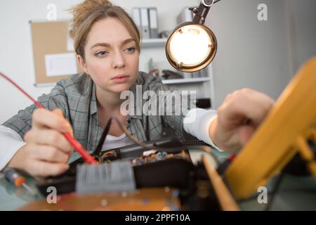 female computer technician using multimeter Stock Photo