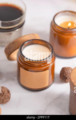 Soy aroma candle in a glass jar with a wooden lid. Copy space label. Beauty and spa. Aromatherapy at home. Scented candles set. Minimalism aesthetic background. Cozy romance mood. Stock Photo