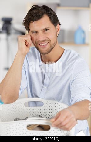 happy man taking clothes from drying rack Stock Photo