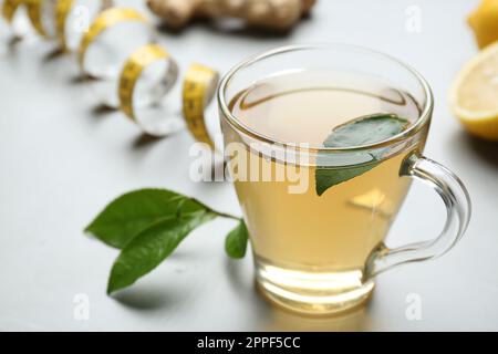 Herbal diet tea and measuring tape on light table Stock Photo