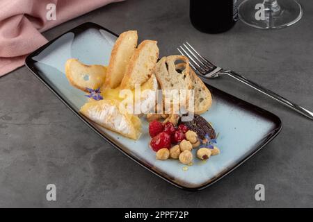 Hot camembert cheese on stone table in fine dining restaurant Stock Photo