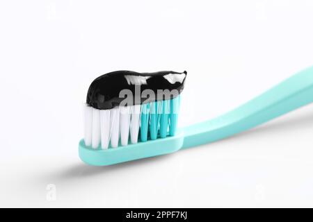 Brush with charcoal toothpaste on white background Stock Photo