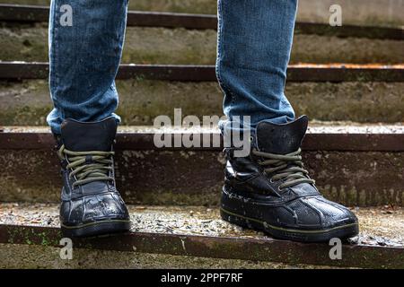 A man in boots on the old steps, close-up. Stock Photo