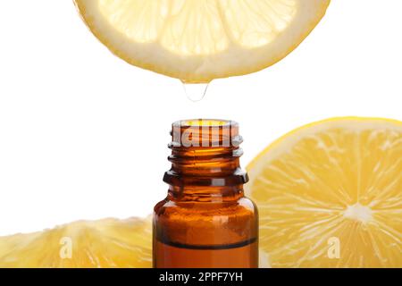 Dripping lemon essential oil from into bottle isolated on white Stock Photo