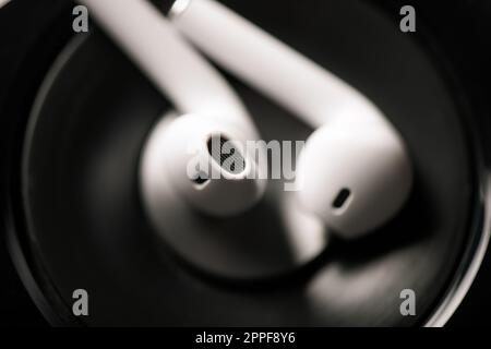 Pair of white wireless earbuds for smartphone. Relaxation concept. Stock Photo