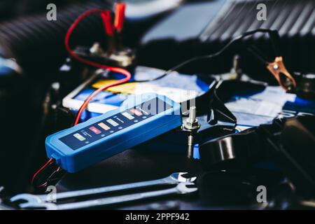 Checking a car battery level with car battery checker, car repairing concept Stock Photo