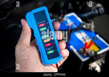 Checking a car battery level with car battery checker, car repairing concept Stock Photo