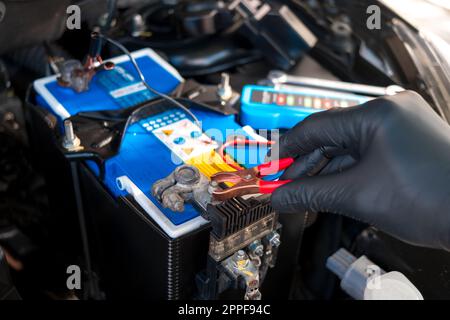 Checking a car battery level with car battery checker, car repairing concept Stock Photo