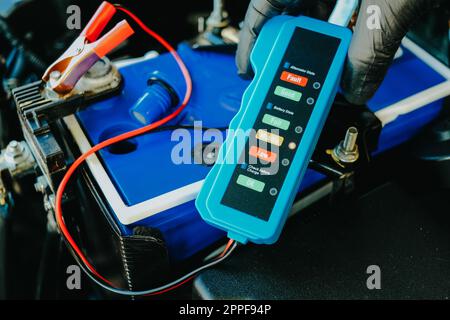 Checking a car battery level with car battery checker, car repairing concept Stock Photo